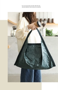Detailed texture of dark green wrinkled DuPont paper tote bag with black fabric handle