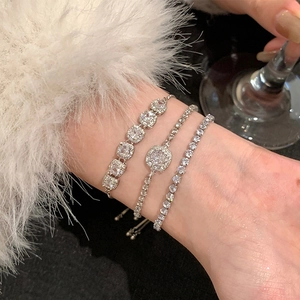 Gros plan d'un ensemble de trois bracelets en zircon argenté porté avec de la fourrure