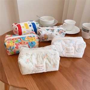 Detailed close-up of quilted cotton makeup bags in various floral and dot patterns