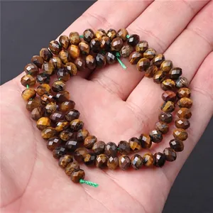 Faceted natural tiger eye loose beads on palm for DIY jewelry making and crafts