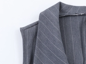 Vue macro d'un gilet gris à rayures montrant la texture du sergé et les coutures