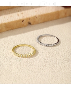 Close-up of gold and silver S925 sterling silver rings with pave-set diamonds on a stone base