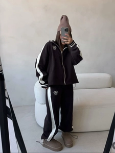 Women's two-piece tracksuit with half-zip sweatshirt and trousers featuring side stripes