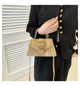 Detail of vintage square handbag featuring a large gold metal buckle and matte texture