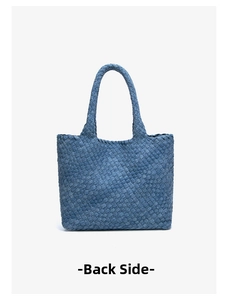 Detail view of the back side of a denim woven tote bag with thick braided handles