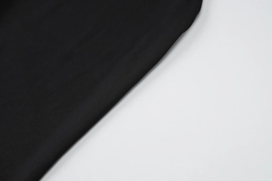 Détail du tissu en maille noire extensible montrant la texture et la finition du matériau
