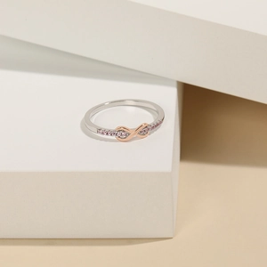 Detail of s925 silver ring with rose gold infinity symbol and pink cubic zirconia accents