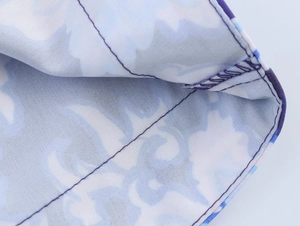 Gros plan du tissu à imprimé fleuri bleu montrant les coutures et la texture du textile