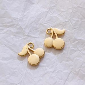 Detailed view of matte gold cherry-shaped metal alloy pendants for DIY jewelry making