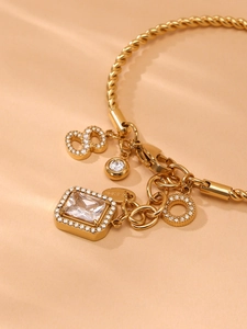 Macro shot of 18K gold stainless steel twisted chain bracelet with cubic zirconia charms