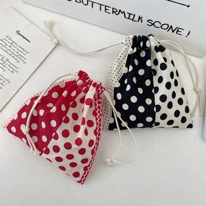 Detailed view of polka dot drawstring storage bags in red and black cotton fabric