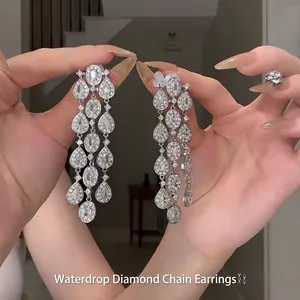 Macro shot of silver teardrop tassel earrings featuring sparkling crystal rhinestones