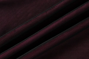 Detail of burgundy mesh fabric showing intricate honeycomb texture and soft drape quality