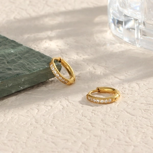 Detailed view of gold stainless steel hoop earrings featuring inlaid white cubic zirconia