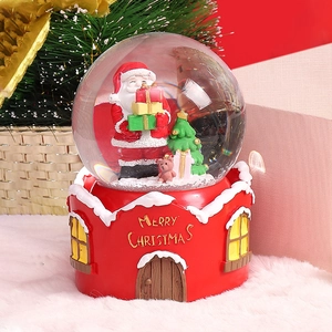 Close-up of a Christmas crystal ball with Santa Claus on a red house base decoration