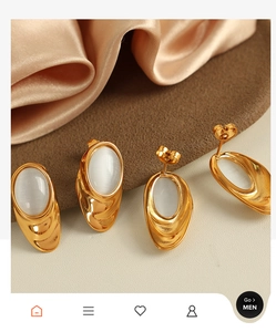Detail of 18k gold plated titanium earrings with white oval opal and textured finish