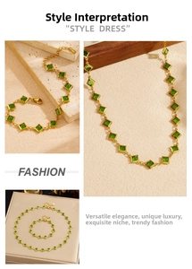 Detailed view of gold stainless steel necklace and bracelet set with emerald green stones