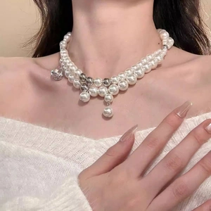 Detail of double-layer pearl necklace featuring silver beads and clear crystal heart pendant