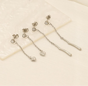 Detail of silver tassel earrings featuring heart and wavy bar charms with sparkling zircon
