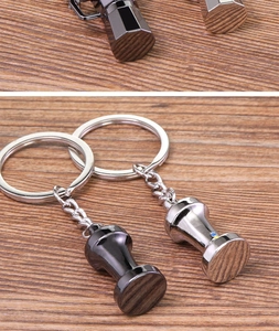 Detail of creative mini moka pot and coffee tamper metal keychain with silver finish