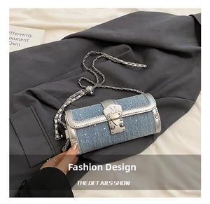 Detail of light blue denim cylinder bag with rhinestones and silver M buckle hardware