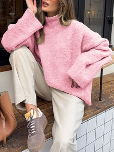Détail du tricot en peluche rose doux sur un pull à col roulé à manches longues