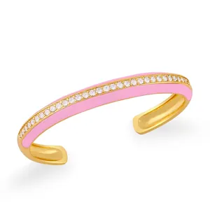 Dettaglio del bracciale dorato con smalto rosa e pavé di zirconi bianchi scintillanti