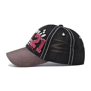 Close-up of vintage washed denim baseball cap featuring side 21 embroidery and brown visor