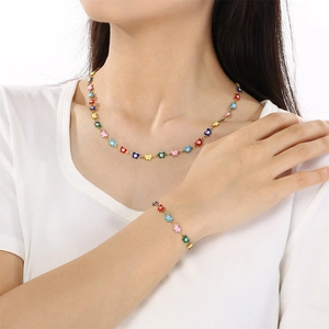 Detail of colorful evil eye charm necklace and bracelet set worn by a fashion model