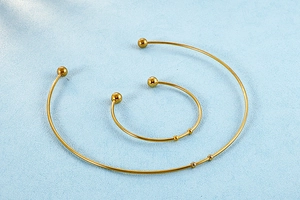 Detailed view of gold stainless steel open choker and bracelet set with sphere accents