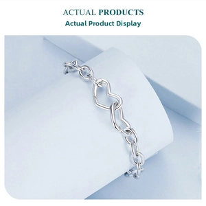 Detail of interlocking twin hearts on a high-polish s925 silver chain bracelet