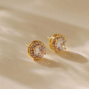 Elegant gold zircon earrings featuring a large clear stone and sparkling halo border