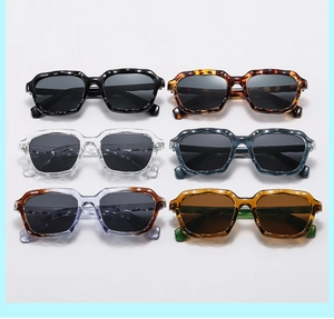 Flat lay of square sunglasses in multiple colors with textured wavy frames and dark lenses