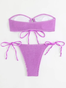 Detail of purple smocked bikini fabric featuring elastic texture and side-tie strings