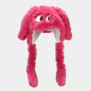 Pink plush monster hat with big white eyes and long earflaps for winter warmth