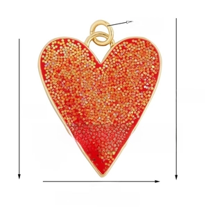 Macro detail of red heart charm with gold border and glitter for necklaces and bracelets
