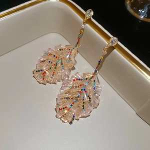 Detail of leaf-shaped earrings with colorful crystals and gold plating in a luxury box