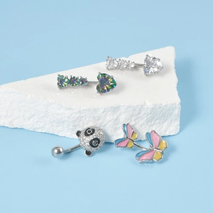 Selection of heart, panda, and butterfly belly rings on white stone display