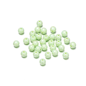 Macro view of light green pearlescent acrylic beads with shimmering iridescent finish