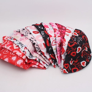 Stack of colorful heart print bucket hats in pink, red and white for Valentine's Day