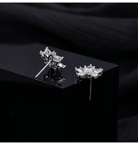 Close-up of S925 sterling silver snowflake earrings with sparkling zircon on black background