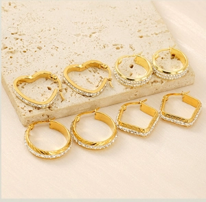 Detail of gold-plated hoop earrings with Greek key pattern and sparkling zircons