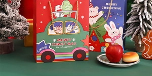 Christmas gift bags in red and blue with festive decorations and golden handles