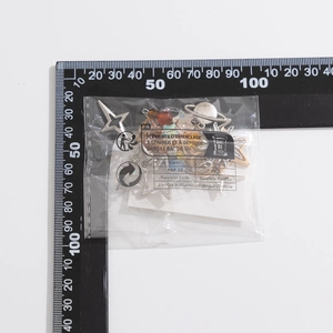 Detailed view of strawberry and star charms in a 7x8cm bag with ruler for scale