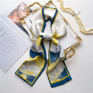 Elegant blue and yellow abstract landscape print skinny silk scarf on a white tray
