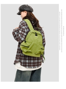 Detail of green nylon space series backpack with multi-layer zippers on female model