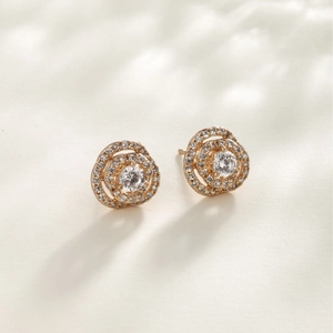 Eleganti orecchini a lobo a doppio cerchio dorati con pavé di zirconi su sfondo beige