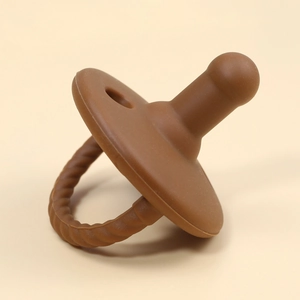 Brown silicone baby teether pacifier close-up view on a clean neutral background