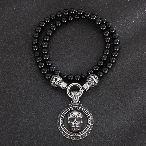 Detailed close-up of double-layer black onyx beads with silver skull round pendant