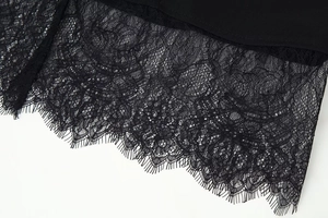 Macro shot of delicate eyelash lace trim on the hem of a black long-sleeve jacket